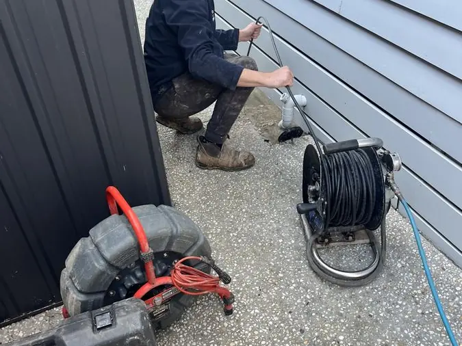 Drain inspection equipment beside a plumber, Chelsea